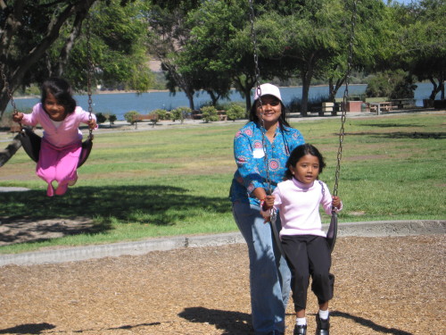 Children and an adult enjoy the swings at the 2007 community picnic.