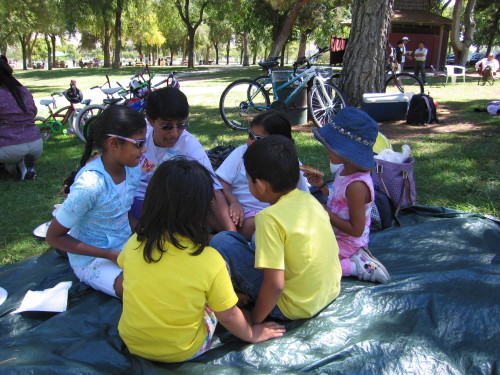 Children sit together on a picnic blanket at the 2007 community picnic.