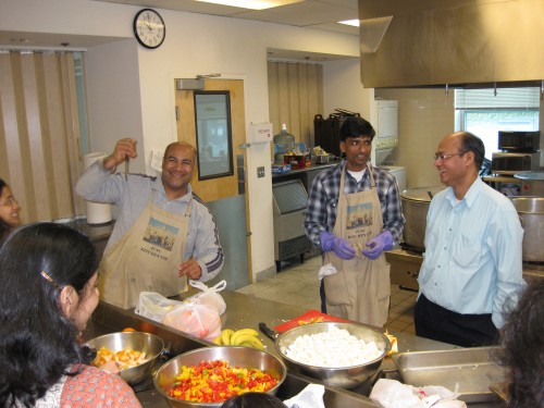 Volunteers work together around a food preparation table at the 2010 Pathshala cooking day.