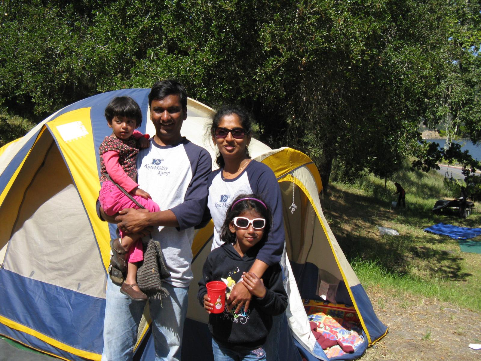 A family stands beside their tent at Camp KV in 2011.